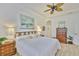 Bright bedroom featuring a ceiling fan, white walls, wood floors and stylish decor at 2292 Sifield Greens Way # 59, Sun City Center, FL 33573