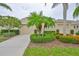 Charming single-story home featuring lush landscaping, mature trees, and a two-car garage at 2292 Sifield Greens Way # 59, Sun City Center, FL 33573
