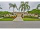 Well-maintained single-story home with a two-car garage, complemented by neatly trimmed hedges and colorful flowers at 2292 Sifield Greens Way # 59, Sun City Center, FL 33573