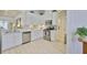 Modern kitchen with white cabinets, stainless steel appliances, and a view into the dining area at 2292 Sifield Greens Way # 59, Sun City Center, FL 33573