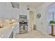 Well-lit kitchen featuring stainless steel appliances, white cabinets, granite countertops, and modern fixtures at 2292 Sifield Greens Way # 59, Sun City Center, FL 33573