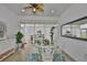 Bright sunroom featuring a ceiling fan, a glass table and views of the backyard at 2292 Sifield Greens Way # 59, Sun City Center, FL 33573