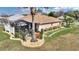 Exterior shot of the backyard featuring a screened-in lanai, stone pathway, landscaped yard and mature trees at 2359 Emerald Lake Dr, Sun City Center, FL 33573