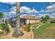 Landscaped backyard featuring a screened-in lanai, stone pathway, manicured lawn, and decorative plants at 2359 Emerald Lake Dr, Sun City Center, FL 33573