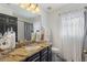 Well-lit bathroom featuring granite counters, dark cabinets, decorative jars, and black and white accents at 2359 Emerald Lake Dr, Sun City Center, FL 33573