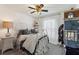Quaint bedroom with a ceiling fan, sheer curtains, and a dollhouse display at 2359 Emerald Lake Dr, Sun City Center, FL 33573