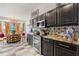 Well-equipped kitchen boasts black cabinetry, stainless steel appliances, and decorative tile backsplash at 2359 Emerald Lake Dr, Sun City Center, FL 33573