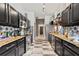 Modern kitchen featuring black cabinetry, stainless steel appliances, and stylish checkerboard flooring at 2359 Emerald Lake Dr, Sun City Center, FL 33573