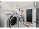 Laundry room featuring a front load washer and dryer, and a wall with shelving at 2359 Emerald Lake Dr, Sun City Center, FL 33573
