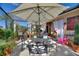Outdoor patio space with umbrellas, a table and chairs, and plenty of plants and shrubbery at 2359 Emerald Lake Dr, Sun City Center, FL 33573