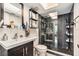 Modern bathroom with dark gray tile, a glass-enclosed shower, floating shelves, and updated fixtures at 2368 Flanders Way # D, Safety Harbor, FL 34695