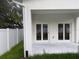 The back porch leads to a grassy backyard area with a white fence at 2404 Cassell St, Tampa, FL 33605