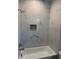 Bright bathroom featuring a marble-tiled shower and chrome fixtures at 2404 Cassell St, Tampa, FL 33605