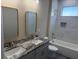 Bathroom with marble countertops, dual sinks, and tub with tiled shower at 2404 Cassell St, Tampa, FL 33605