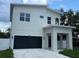 Modern two-story home with a two-car garage and a white fence at 2404 Cassell St, Tampa, FL 33605