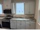 Modern kitchen featuring white cabinets, stainless steel appliances, and stone countertops at 2404 Cassell St, Tampa, FL 33605