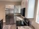 Bright kitchen featuring stainless steel appliances, stone countertops, and wood-look flooring at 2404 Cassell St, Tampa, FL 33605