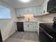 Updated kitchen featuring white cabinets, black appliances, and modern countertops for a sleek design at 2459 Columbia Dr # 39, Clearwater, FL 33763