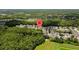 Overhead view of homes in a community near a large wooded area with a pond at 2537 Stanhope Dr, New Port Richey, FL 34655