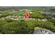 A view of the community, surrounded by lush greenery, near a pond and a field at 2537 Stanhope Dr, New Port Richey, FL 34655