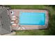 Birds-eye view of community pool with ample seating, brick patio, and black metal fence at 2537 Stanhope Dr, New Port Richey, FL 34655