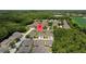 Aerial view of homes in a community surrounded by lush greenery and a calm pond at 2537 Stanhope Dr, New Port Richey, FL 34655