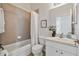 Bright bathroom featuring a bathtub with shower, and a single sink vanity with white cabinets at 2537 Stanhope Dr, New Port Richey, FL 34655