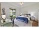 Bright bedroom features a blue headboard, desk, and a sliding glass door to the backyard at 2537 Stanhope Dr, New Port Richey, FL 34655