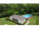 Aerial view of a community pool surrounded by a fence and lush green landscape at 2537 Stanhope Dr, New Port Richey, FL 34655