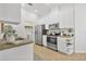 Bright kitchen featuring stainless steel appliances and white cabinetry and tile floor at 2537 Stanhope Dr, New Port Richey, FL 34655