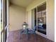 Patio with brick flooring and furniture, with a view into the bedroom through sliding glass doors at 2537 Stanhope Dr, New Port Richey, FL 34655