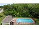 Community pool with lounge chairs and table, surrounded by brick and a black metal fence at 2537 Stanhope Dr, New Port Richey, FL 34655