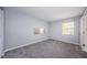 Spacious bedroom featuring soft gray walls, plush carpet, and a window for natural light at 2690 Coral Landings Blvd # 122, Palm Harbor, FL 34684