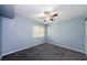 Comfortable bedroom featuring soft blue walls, plush carpet, ceiling fan, and a window for natural light at 2690 Coral Landings Blvd # 122, Palm Harbor, FL 34684