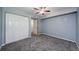 Comfortable bedroom featuring soft blue walls, plush carpet, ceiling fan, and a double closet at 2690 Coral Landings Blvd # 122, Palm Harbor, FL 34684