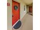 Entrance to the unit features a vibrant red door with decorative wreath and tiled walkway at 2690 Coral Landings Blvd # 122, Palm Harbor, FL 34684