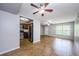 Bright living room with tile flooring, ceiling fan, and a view into the kitchen with stainless appliances at 2690 Coral Landings Blvd # 122, Palm Harbor, FL 34684