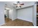 Neutral living room featuring tiled floors, ceiling fan, and adjacent access to the bathroom at 2690 Coral Landings Blvd # 122, Palm Harbor, FL 34684