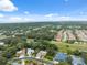 An aerial view of a subdivision neighborhood featuring houses with pools and lots of trees at 3037 Crest Dr, Clearwater, FL 33759