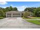 Charming single-story home with a two-car garage and a well-manicured lawn and mature trees at 3037 Crest Dr, Clearwater, FL 33759