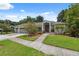 Inviting single-story home with a two-car garage and a meticulously maintained front yard at 3037 Crest Dr, Clearwater, FL 33759