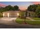 Charming single-story home with a well-manicured lawn, mature trees, and a two-car garage during sunset at 3037 Crest Dr, Clearwater, FL 33759
