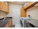 Laundry room with wooden cabinets, sink, and modern washer and dryer at 3037 Crest Dr, Clearwater, FL 33759