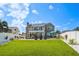 Expansive backyard featuring lush lawn, a swimming pool, patio, and a charming home exterior at 311 22Nd St, Belleair Beach, FL 33786