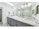 Bathroom featuring dual sinks, marble countertops and a glass shower at 311 22Nd St, Belleair Beach, FL 33786