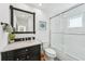 Bathroom boasts a sleek black vanity, a framed mirror, and a glass-enclosed shower at 311 22Nd St, Belleair Beach, FL 33786