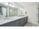 Bathroom featuring dual sinks, marble countertops and a glass shower at 311 22Nd St, Belleair Beach, FL 33786