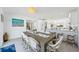 Open concept dining area features a rustic table, wicker chairs, modern chandelier, and an open layout at 311 22Nd St, Belleair Beach, FL 33786