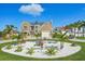 Beautiful two-story home boasting manicured landscaping, a paver driveway, and elegant architectural details on a bright day at 311 22Nd St, Belleair Beach, FL 33786