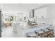 Bright kitchen features an island, white cabinets, granite countertops, stainless steel appliances, and breakfast bar at 311 22Nd St, Belleair Beach, FL 33786